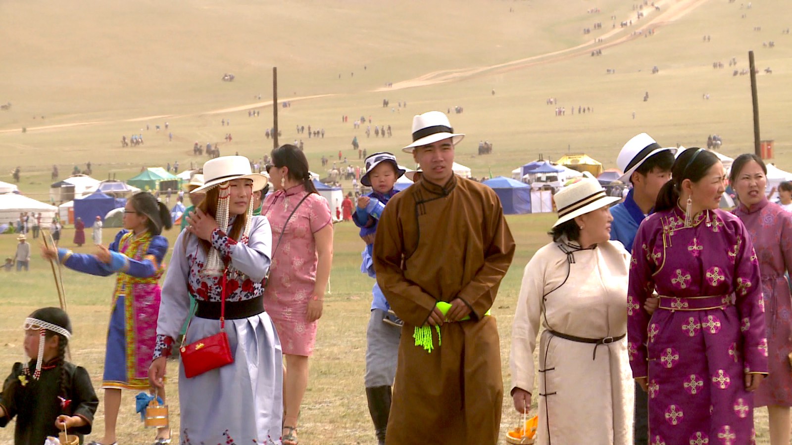 Naadam Festival Mongolei mit festlich gekleideten Menschen in traditioneller Kleidung